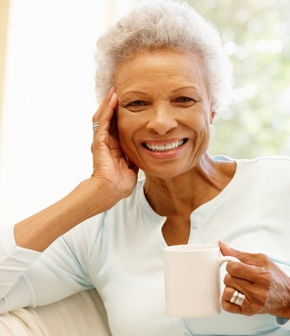 Smiling senior woman holding white coffee mug
