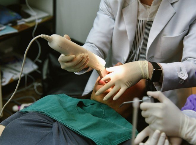 Dentist taking digital impressions of teeth