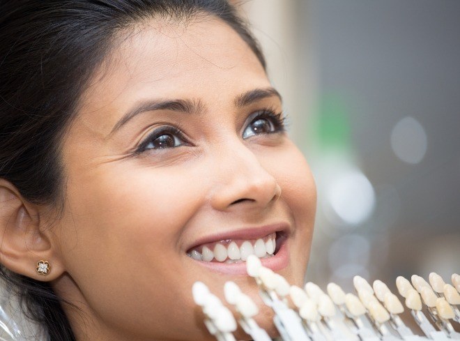 Smiling woman trying on dental veneers