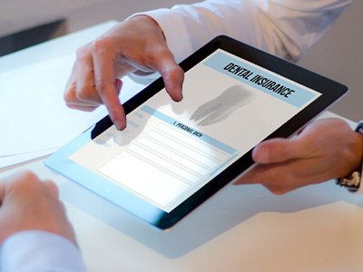 Patient reviewing dental insurance forms on tablet