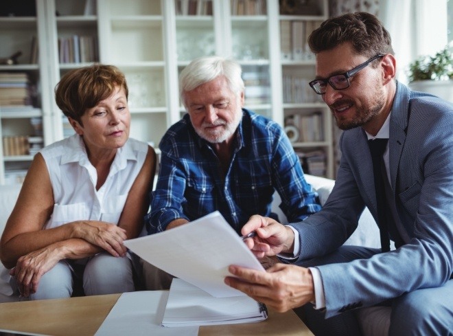 Man in suit talking to senior couple about finances