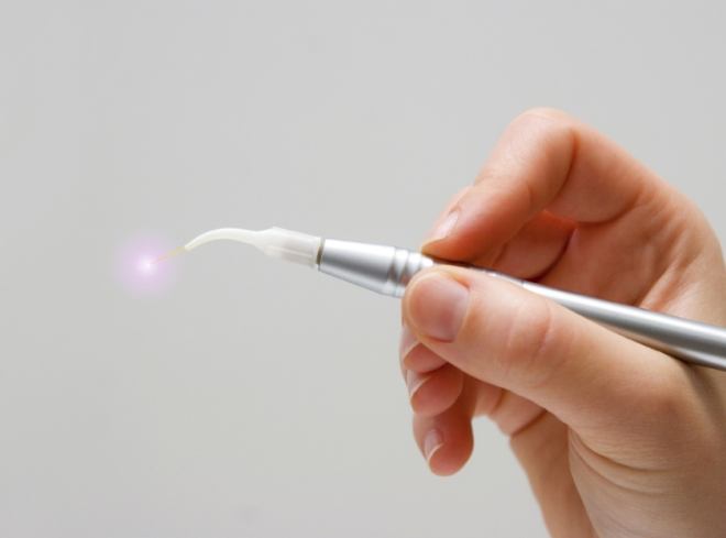 Hand holding a thin silver soft tissue laser