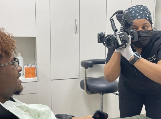 Dental team member taking picture of patient smiling after treatment