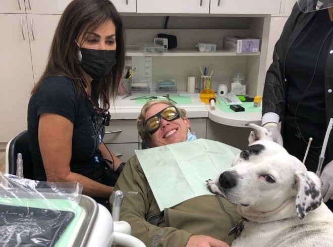 Doctor Alani with dental patient and Piper the therapy dog