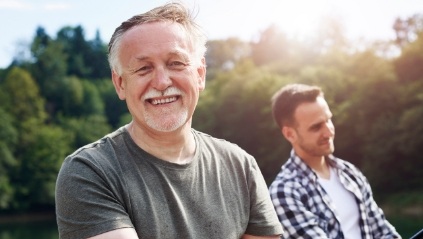 Smiling older man on a boat with his son