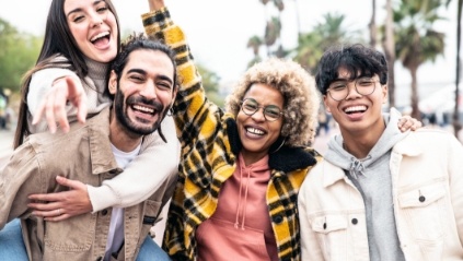 Four people laughing together outdoors