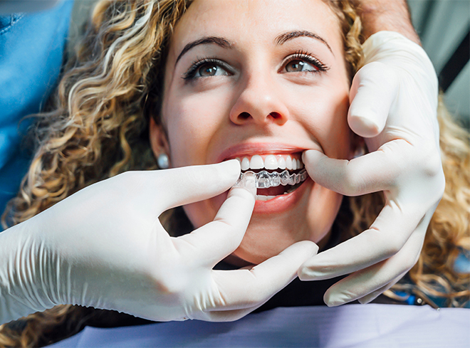 Dentist fitting a patient with Invisalign in Houston