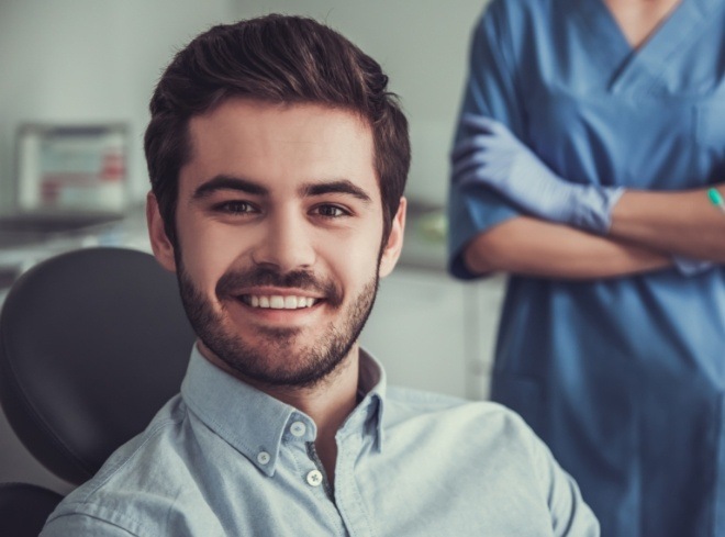 Young man with short beard smiling in dental chair