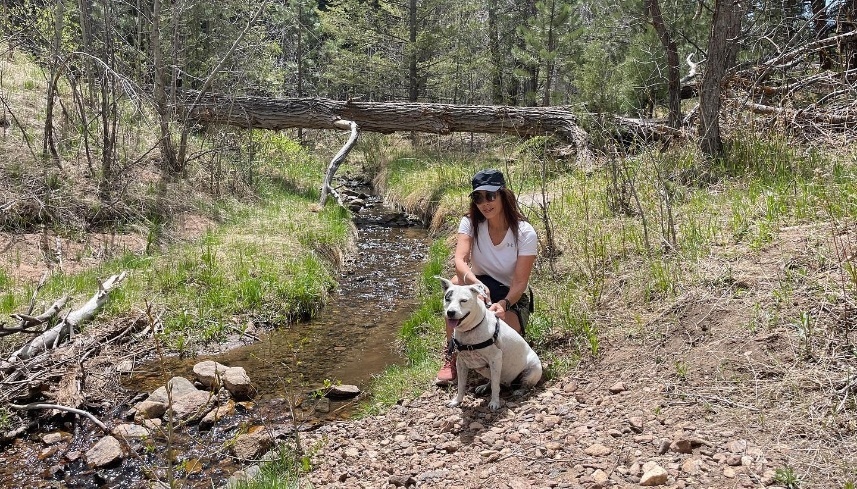 Doctor Alani and Piper next to small creek in woods