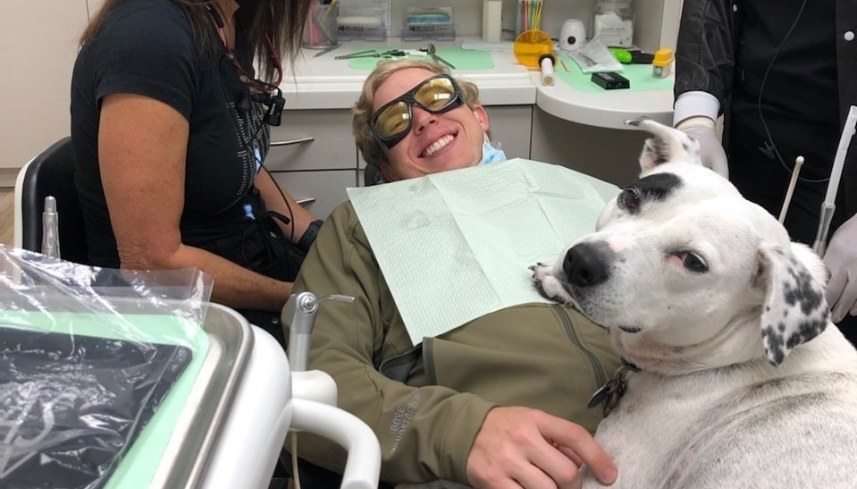 Smiling dental patient and Piper turning back to look at camera