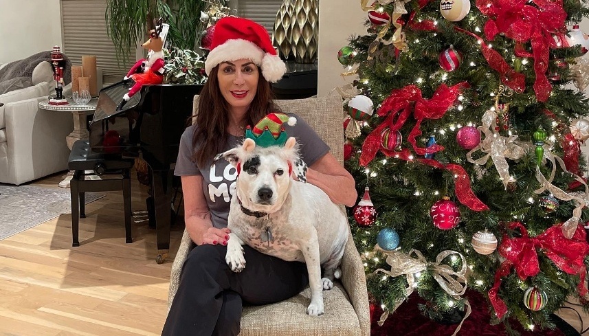 Doctor Alani and Piper both wearing Christmas hats while sitting next to Christmas tree