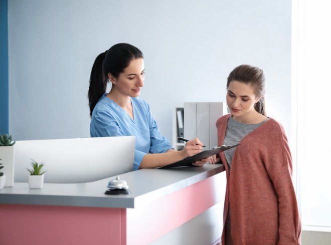 Dental team member showing a clipboard to a patient