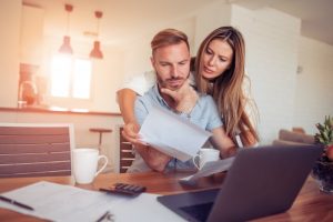 A concerned couple examining bills.