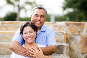 An older couple smiling outside.