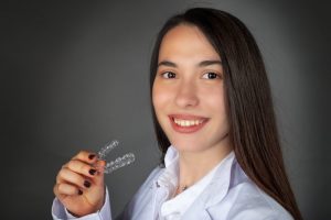 a woman holding Invisalign braces