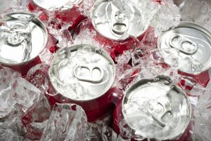 A six pack of soda covered in ice.