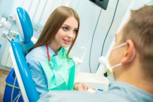 Woman learning oral hygiene tips from a dentist in Uptown.