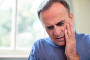 Man suffering from tooth pain.