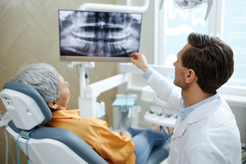 A dentist looking at x-rays with a patient